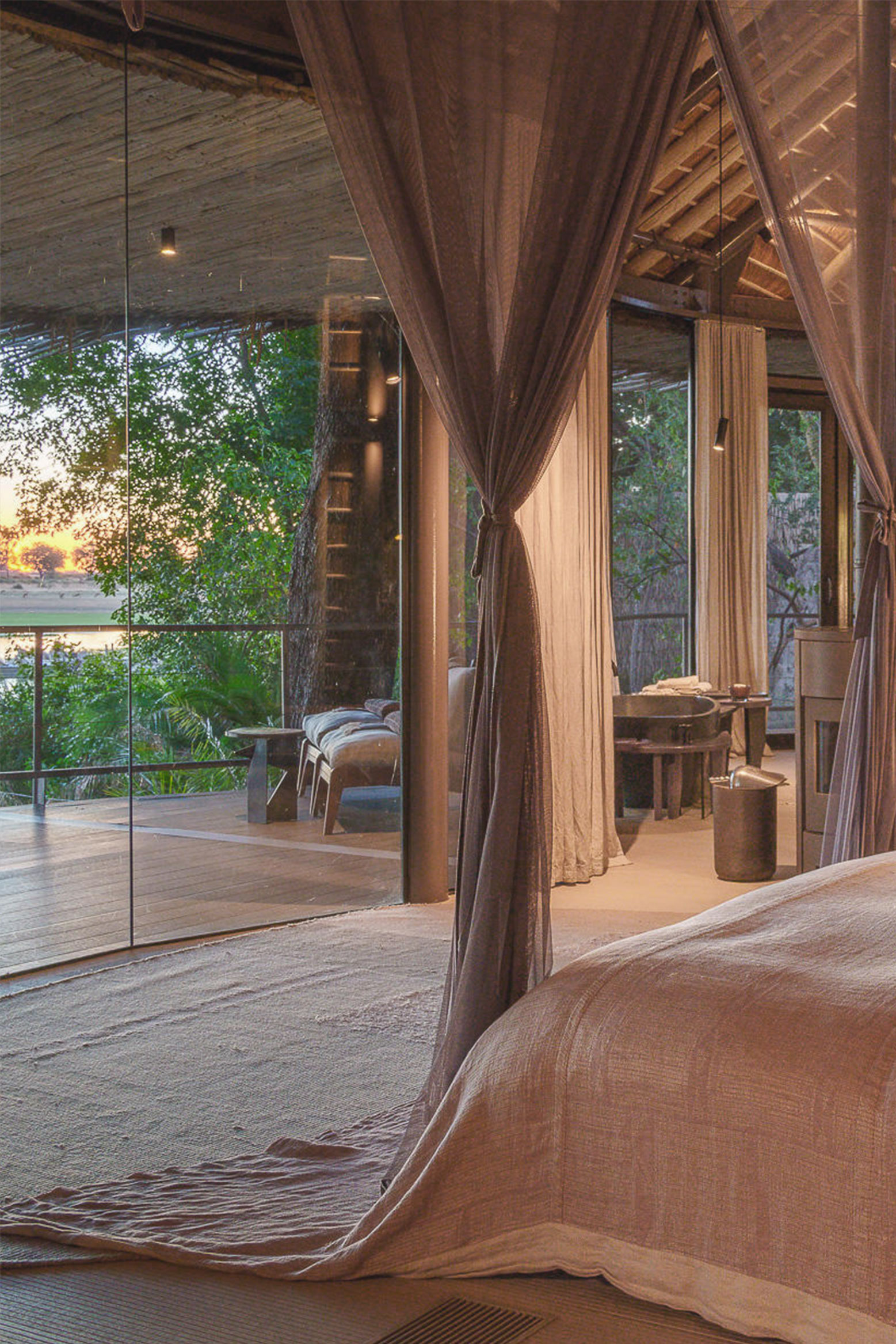 Draped four-poster bed opening onto a private deck over the Delta